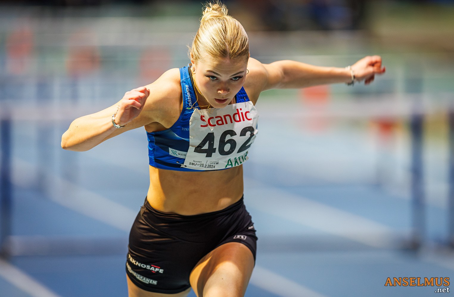 Yleisurheilija juoksemassa aitoja yleisurheilukentällä